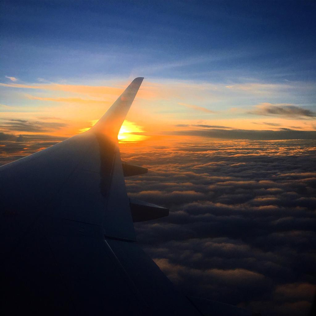sunrise over clouds inside airplane