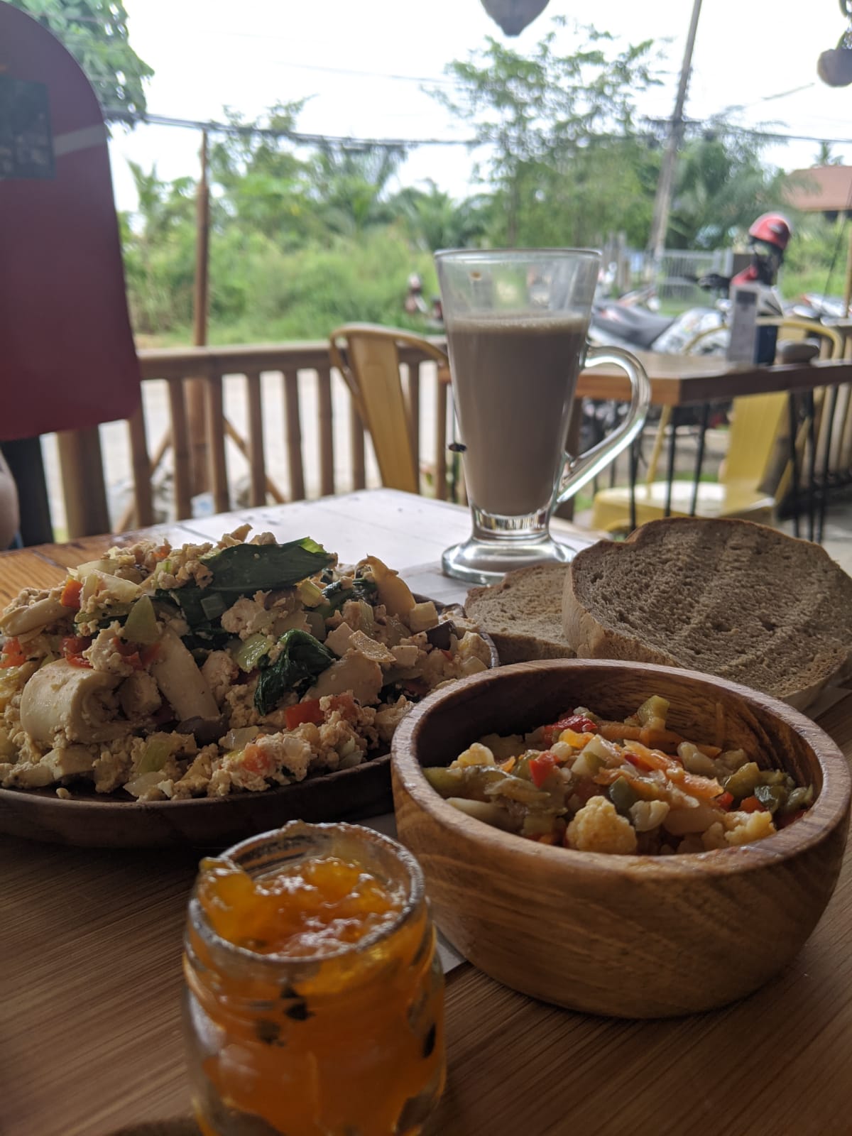 Vegan brunch plates and a latte on the terrace at Pura Vida Café, Koh Phangan