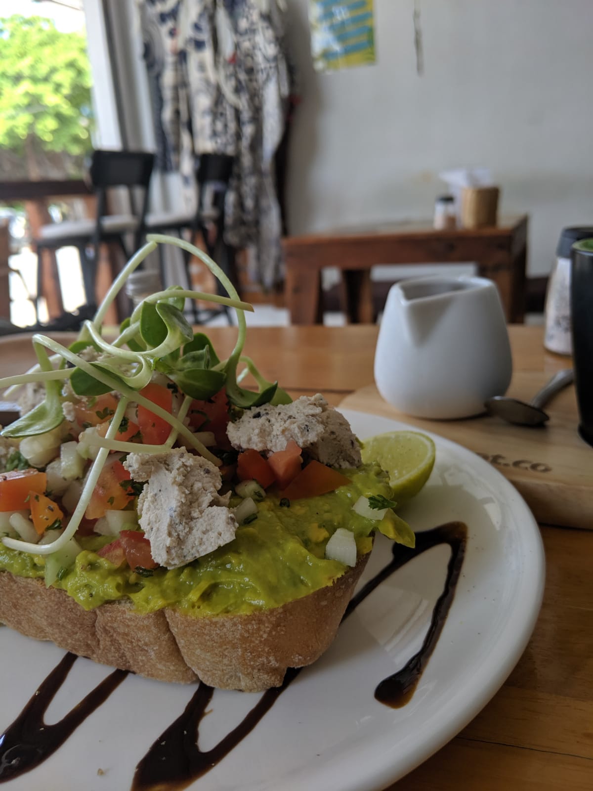 Vegan avocado toast topped with tomato and sprouts at Eat.Co in Sri Thanu, Koh Phangan