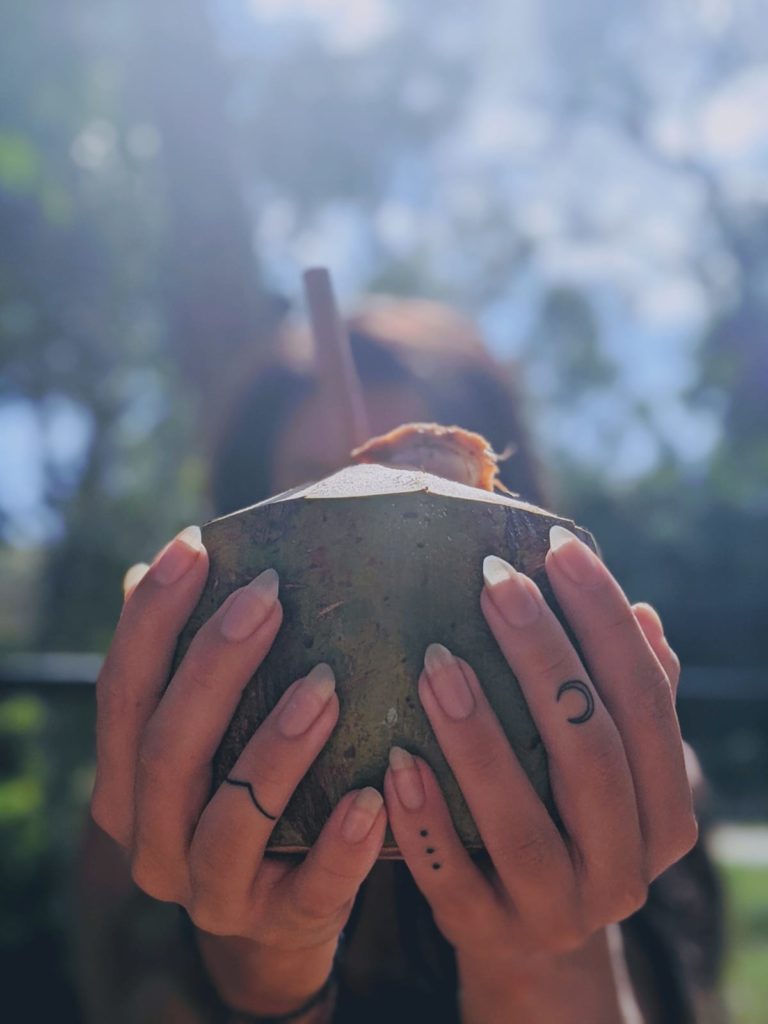 finger tattoos holding a coconut