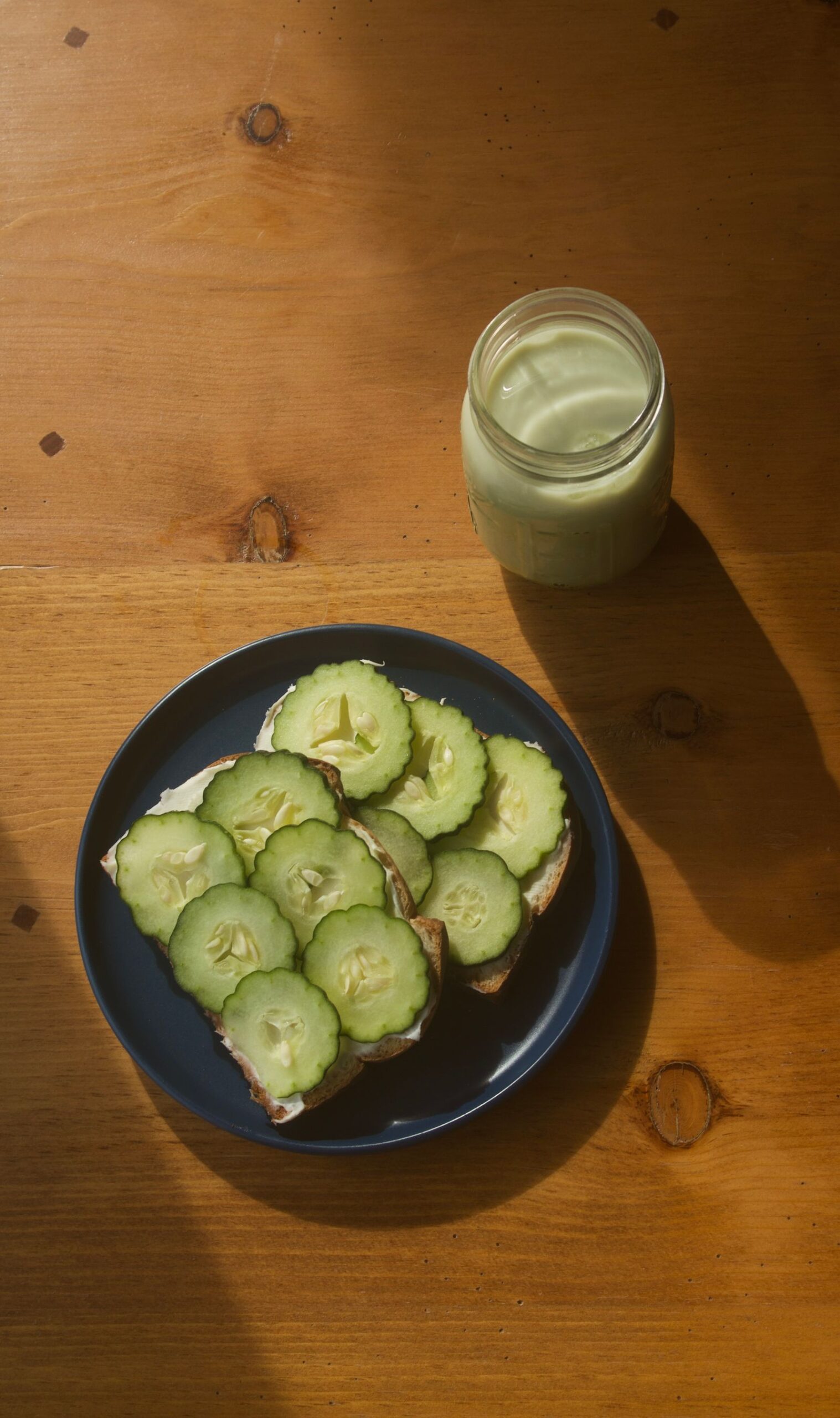 Cucumber toast and a matcha latte on a wooden café table