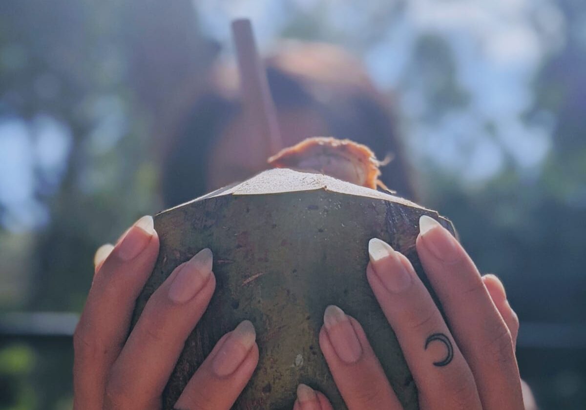 finger tattoos holding a coconut